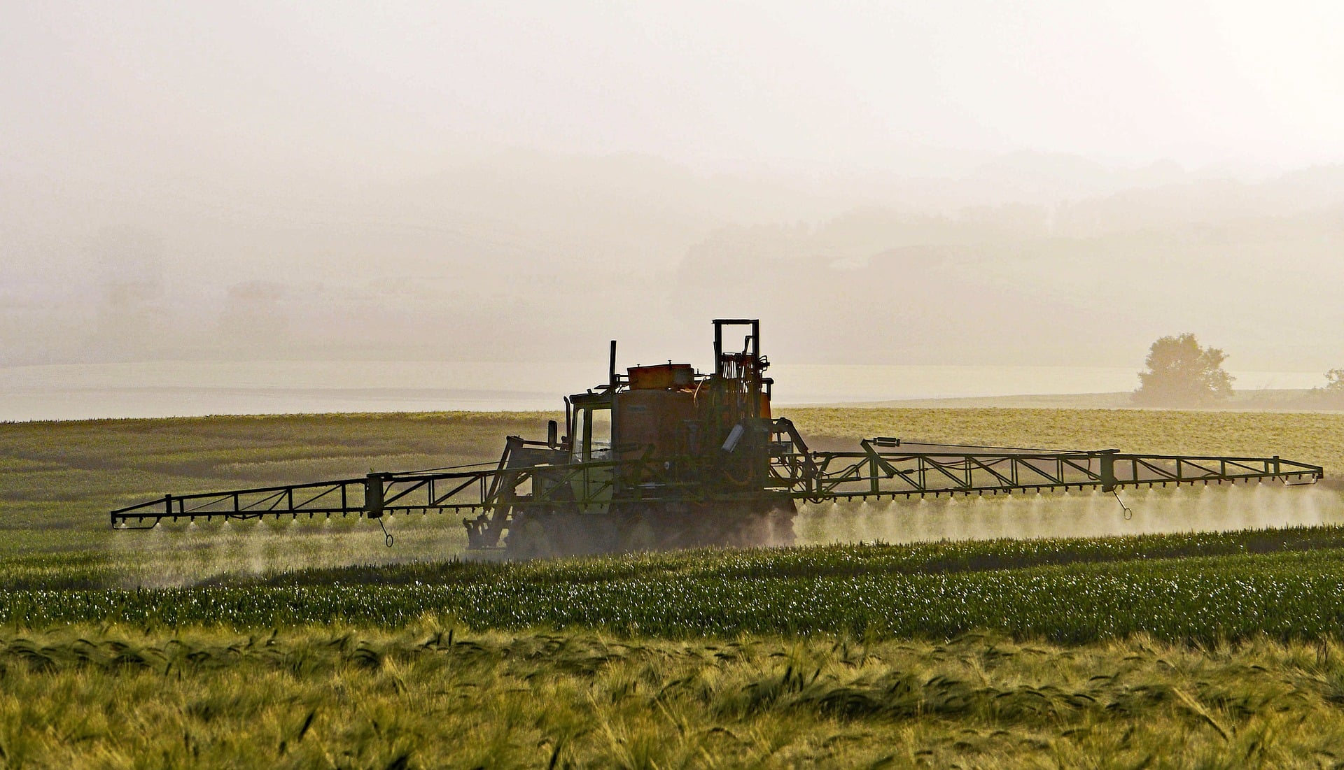 a tractor spreading agrochemicals on a field