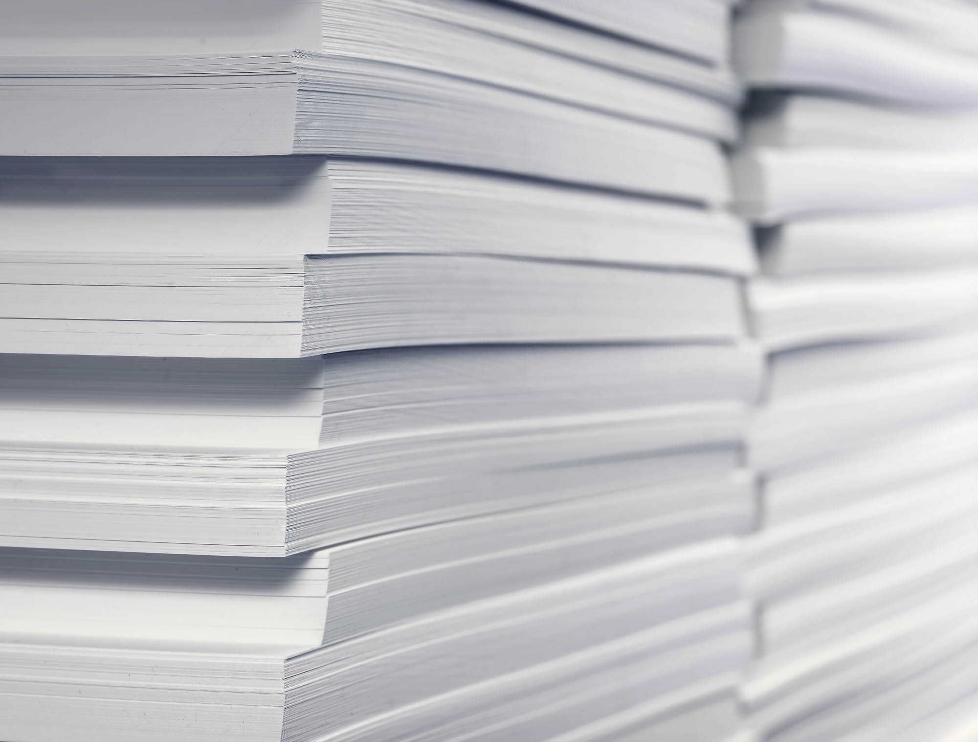 close -up of stack with white printing and writing papers