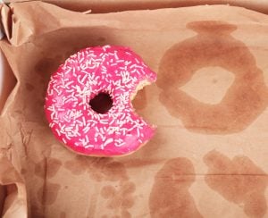 Delicious donut on greasy paper in box