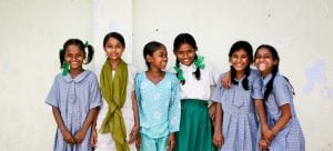 young girls in colorful clothes smiling into the camera